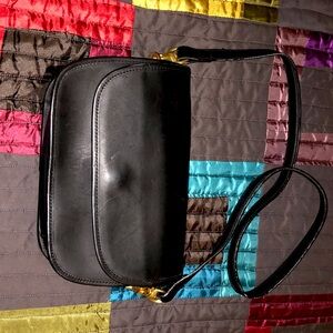 COACH Black shoulder bag with brass hook attachment.